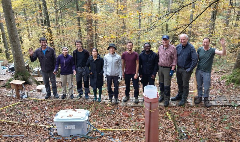 Team photo of ten people in in front of one of the heated plots