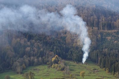 Cloud of smoke over a forest slope