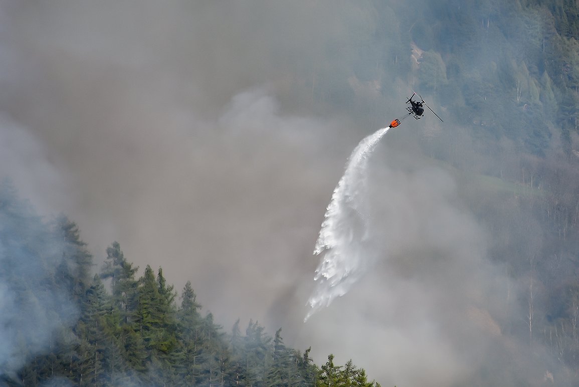 Un elicottero spegne un incendio boschivo.