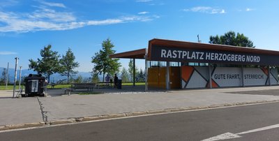 Ansicht eines Autobahn-Rastplatzes mit befallenen Eichen im Hintergrund